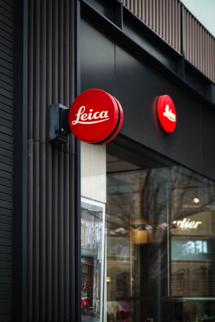 Vertical shot of a modern Leica store facade, highlighting urban architectural design.